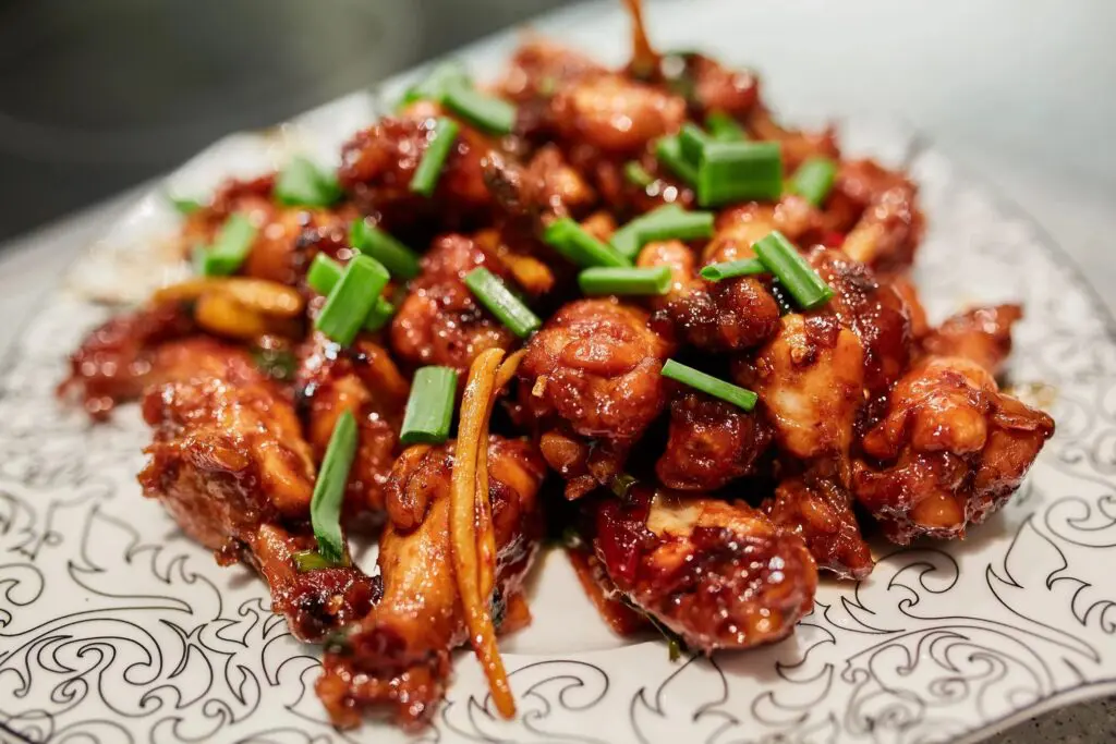 A plate of food with meat and green onions.